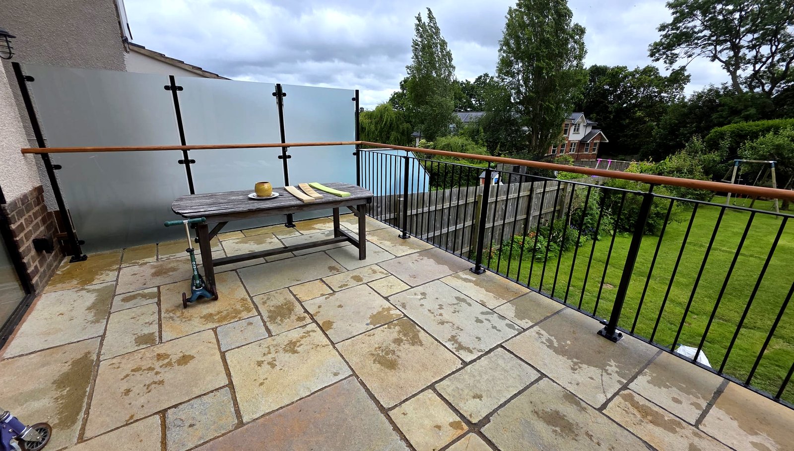 Frosted glass privacy screen with solid oak handrail above black metal railings, Sheffield terrace